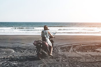 Woman Riding Motor Scooter on Seashore