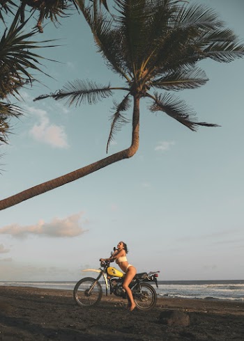 Woman Riding Motorcycle Under Palm Tree