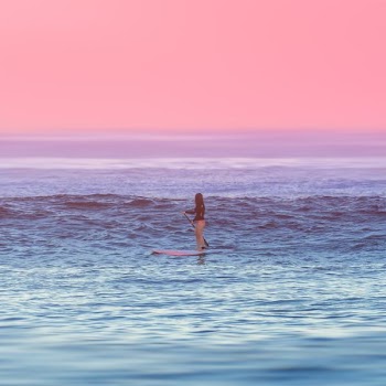 woman riding paddle boat at the middle of the ocean