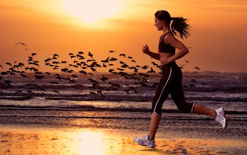 woman running on the beach and sunset