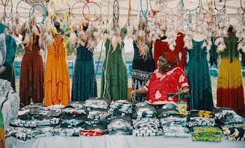 Woman Seated Next to Assorted Dresses
