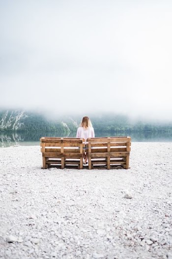woman seating on brown bench