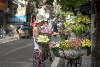 Woman Selling Flowers on Roadside