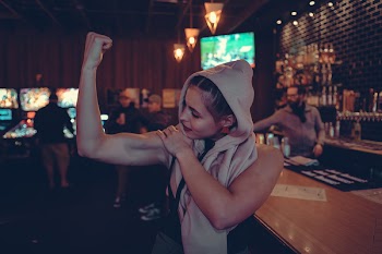 Woman Showing Biceps in Bar