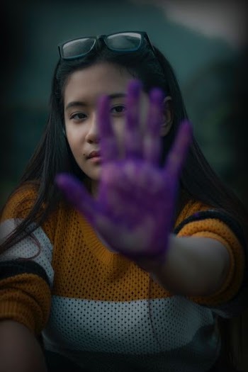 woman showing her left hand with purple paint