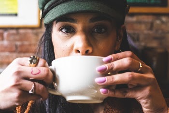 Woman Sipping in White Ceramic Teacup