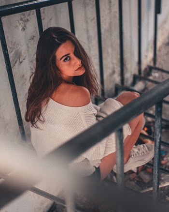 Woman Sits on Black Metal Railing Taken