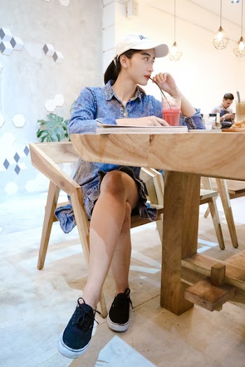 Woman Sits on Brown Wooden Chair Near Brown Table Inside Room