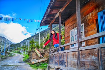 Woman Sits on Cabin's Balcony