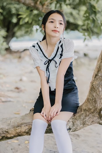 Woman Sits on Wood Branch