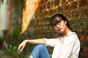 Woman Sitting Against Wall