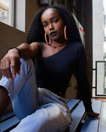 Woman Sitting and Leaning on Black Wooden Surface