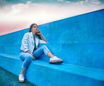 Woman Sitting And Leaning On Blue Concrete Bench