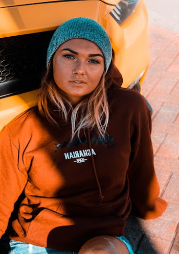 Woman Sitting and Leaning on Yellow Vehicle