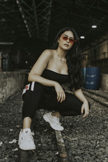 Woman Sitting and Posing on Railroad Track