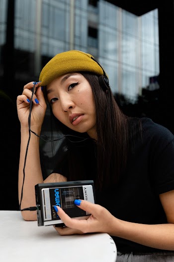 Woman Sitting and Using Sony Walkman Portable Music Player