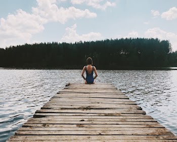 Woman Sitting at the Edge of a Pier