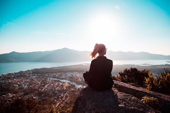 Woman Sitting at the Edge of Mountain