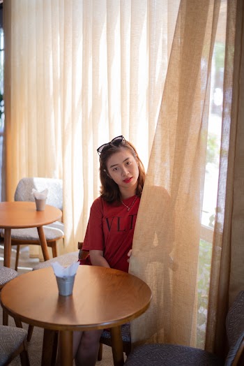 Woman Sitting Behind Curtain