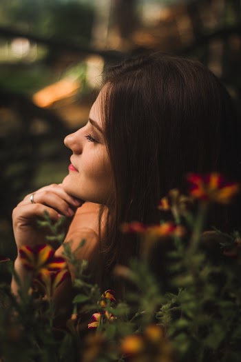 Woman Sitting Behind Flowers