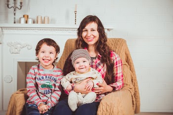 Woman Sitting Beside A Boy While Carrying A Baby 