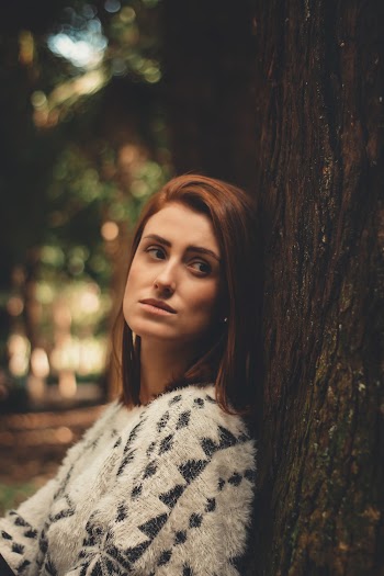 Woman Sitting Beside Brown Tree Bark