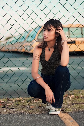 Woman Sitting Beside Fence