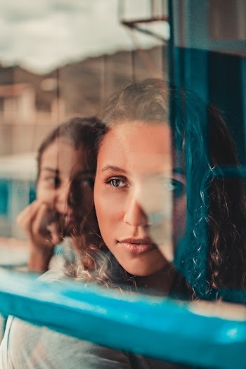 Woman Sitting Beside Glass Window