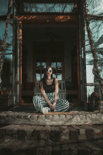 Woman Sitting Beside House