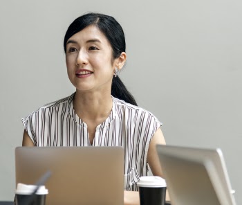 Woman Sitting Beside Laptop Computer and Two Cups of Coffee