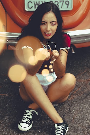 Woman Sitting Beside Orange Vehicle
