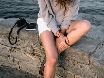 Woman Sitting Beside Smartphone and Camera