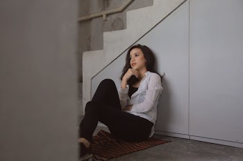 Woman Sitting Beside Staircase