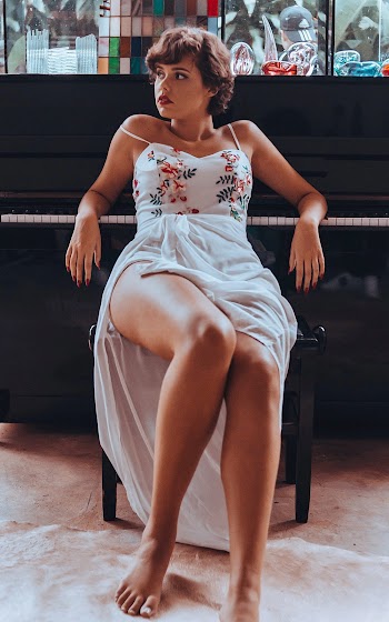 Woman Sitting Beside Upright Piano Looking Sideward