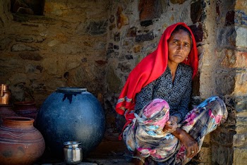 Woman Sitting Beside Wall