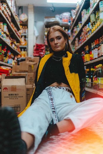woman sitting between display shelves