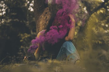 Woman Sitting Covered in Pink Smoke