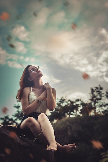 Woman Sitting Down and Touching Own Shoulder