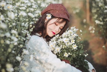 Woman Sitting Down Carrying Bouquet of White Flowers