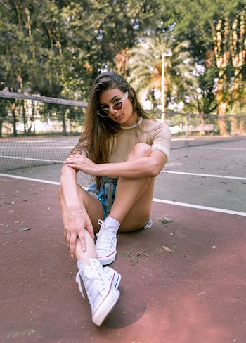 Woman Sitting Down On Tennis Court