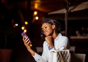 Woman Sitting Holding a Phone