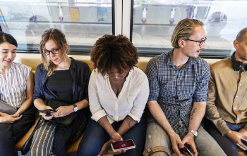 Woman Sitting Holding Smartphone Between Two Men and Two Women