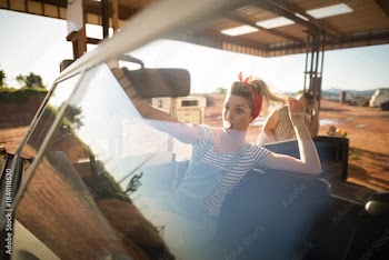 Woman sitting in car on a sunny day