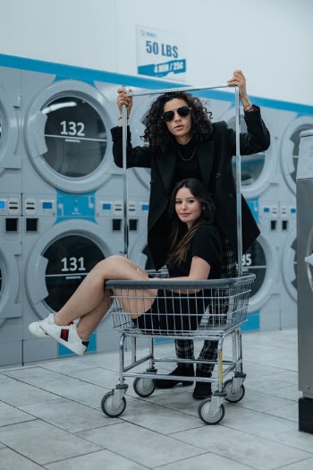 Woman Sitting in Cart and Man in Laundromat · Free Stock Photo