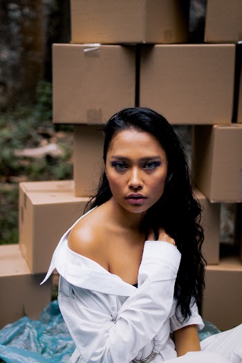 Woman Sitting in Front of Piled Brown Cardboard Boxes