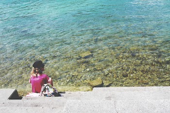 Woman Sitting in Front of Sea during Daytime