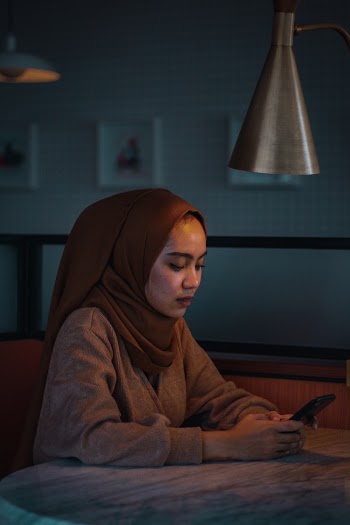 Woman Sitting In Front Of Table