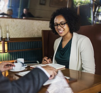 Woman Sitting in Front of Table Looking at Book