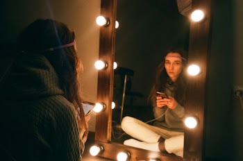 Woman Sitting in Front of Vanity Mirror