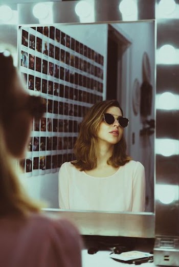 woman sitting in front of vanity mirror